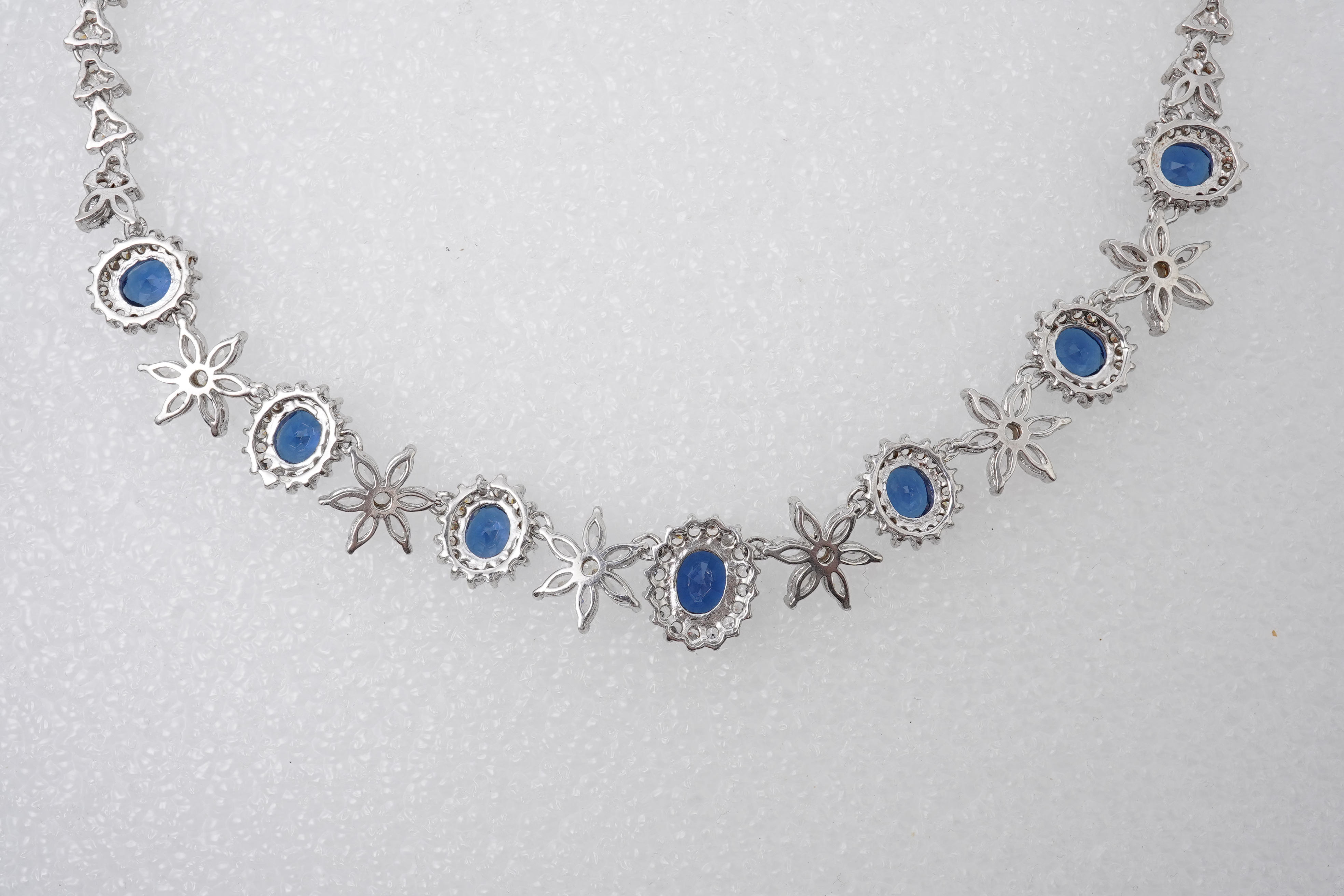 A synthetic sapphire and cubic zirconia necklace and two pendants, the necklace set with oval synthetic sapphires and brilliant-cut and marquise-shaped cubic zirconias, mounted in silver, length 44cm, stamped 925; togeth